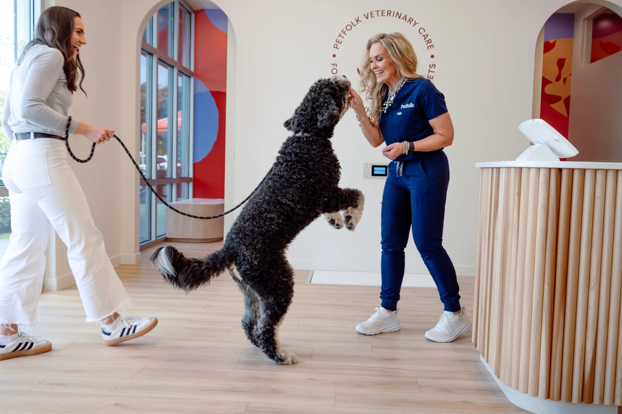 Petfolk vet greeting a dog at a clinic
